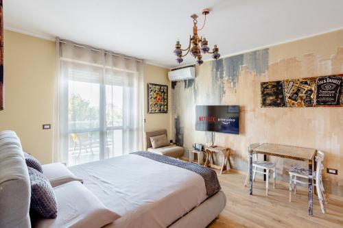 a bedroom with a bed and a table and a tv at [3' a piedi dal mare] CASITA DEL MAR...Mare & Arte in Grottammare
