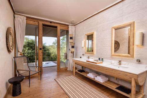 W łazience znajduje się umywalka i lustro. w obiekcie JW Marriott Masai Mara Lodge w mieście Masai Mara