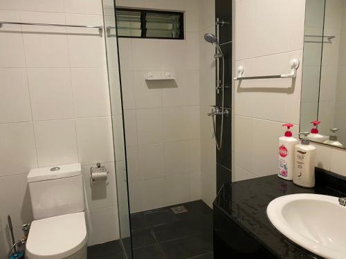 a bathroom with a shower and a toilet and a sink at The Floorspace Imperial Suites Apartment in Kuching