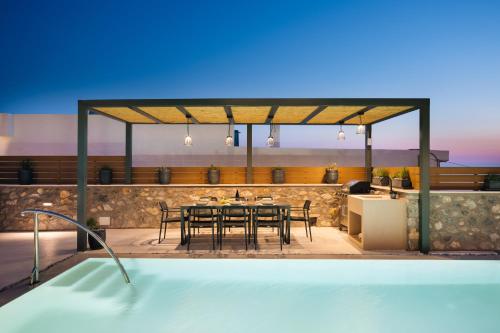 a dining area with a table and chairs on a patio at Mirthea Suites in Mírthios