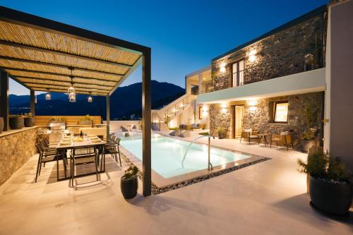 a villa with a swimming pool at night at Mirthea Suites in Mírthios