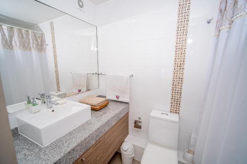 Baño blanco con lavabo y aseo en Hermoso departamento en la Peninsula, en Iquique