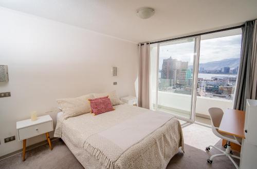 1 dormitorio con cama y ventana grande en Hermoso departamento en la Peninsula, en Iquique