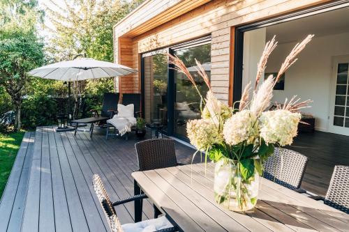 un tavolo in legno con un vaso di fiori su un ponte di X Kowloon a Westerholz