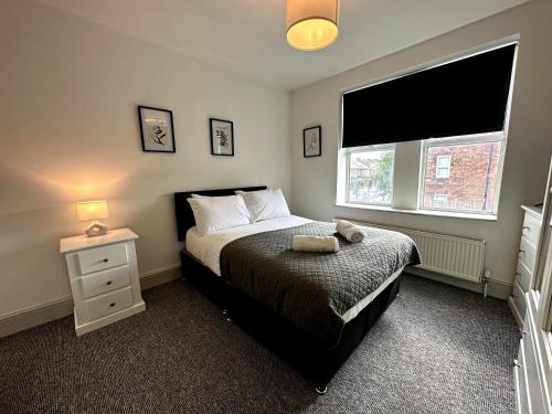 1 dormitorio con 1 cama, mesita de noche y ventana en Stylish 3Bed apartment with FREE PARKING en Heaton