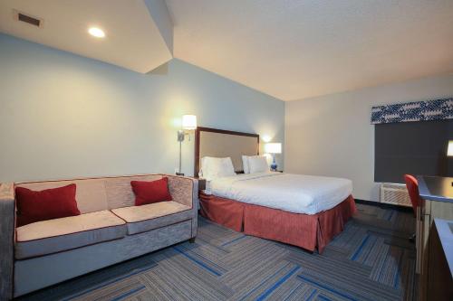 a hotel room with a bed and a couch at Hampton Inn Bordentown in Bordentown