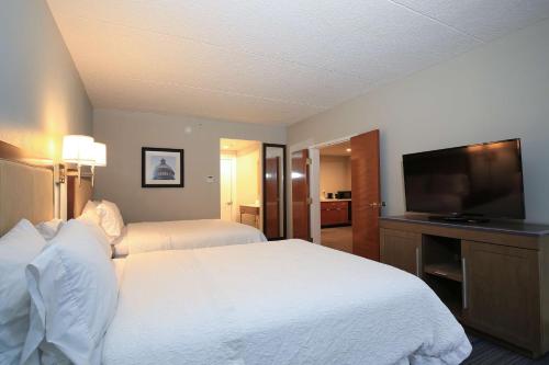 a hotel room with a bed and a flat screen tv at Hampton Inn Bordentown in Bordentown