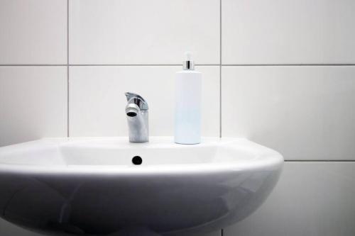 - un lavabo blanc dans la salle de bains carrelée dans l'établissement K Suites - Lansdown Road 2, à Bristol