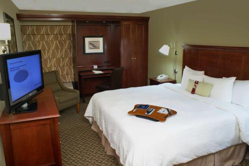 a hotel room with a bed and a flat screen tv at The Addison Hotel SureStay Collection by Best Western in Addison