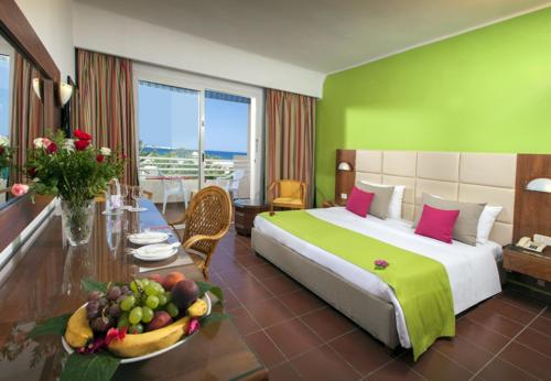 a hotel room with a bed and a table with a bowl of fruit at Regency Hammamet in Hammamet Sud