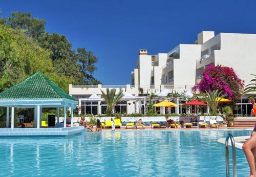a large swimming pool with a hotel in the background at Regency Hammamet in Hammamet Sud