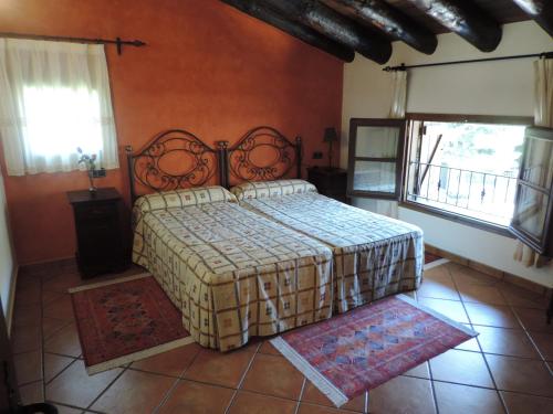 1 dormitorio con 1 cama y 2 ventanas en El Prau De Vidal, en La Puebla de Roda