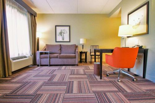 a hotel room with a couch and a desk and a chair at Hampton Inn & Suites Flowery Branch in Flowery Branch