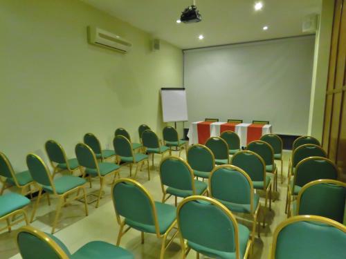 an empty room with chairs and a white screen at Grand Hotel in Reconquista