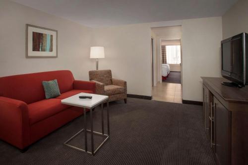 a living room with a red couch and a tv at Hampton Inn & Suites Milwaukee Downtown in Milwaukee