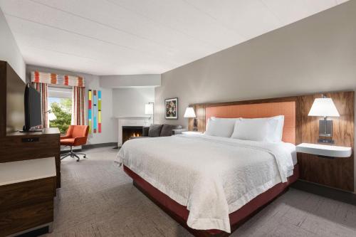 um quarto de hotel com uma cama grande e uma lareira em Hampton Inn Quakertown em Quakertown