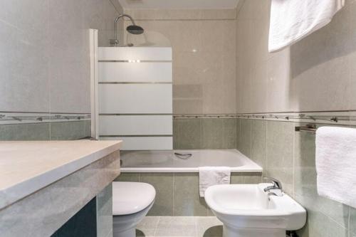 La salle de bains blanche est pourvue de toilettes et d'un lavabo. dans l'établissement Don Juan - Apartament - Manilva, à Manilva