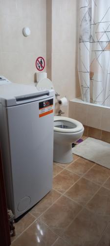 a bathroom with a toilet and a small refrigerator at Vasi in Markopoulo