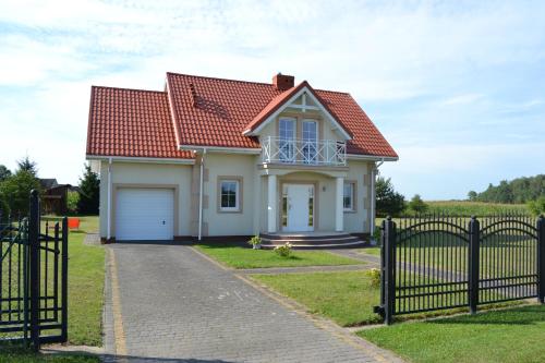 a small white house with a red roof at Domek mamy in Tykocin