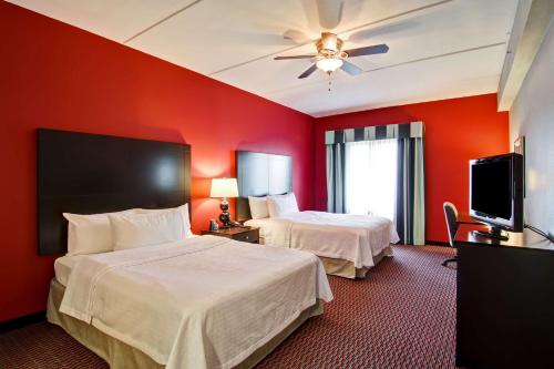 a hotel room with two beds and a flat screen tv at Homewood Suites by Hilton Leesburg in Leesburg