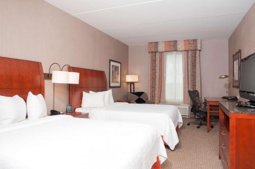 ein Hotelzimmer mit 2 Betten und einem TV in der Unterkunft Hilton Garden Inn Columbus Edinburgh in Edinburgh
