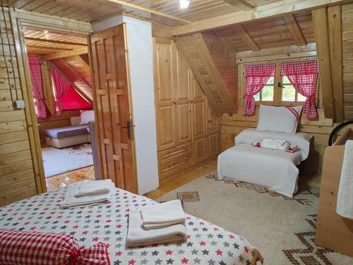 1 dormitorio con 2 camas en una cabaña de madera en Vila Maja, en Rudno
