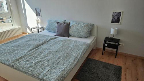 um quarto com uma cama com um cobertor azul e uma janela em FeWo L19 One - Nespresso, Parkplatz em Bamberg
