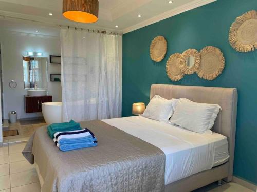 a bedroom with a bed with a blue wall at Beautiful 3 rooms apartment, 2 beds & 1 dressing room in Flic-en-Flac