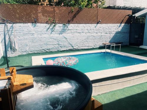 a swimming pool with a tub in a backyard at CASA 1er piso completo con piscina temperada, tinaja y quincho próxima a Playa Sn Alfonso in Algarrobo