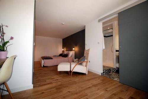 une chambre avec un lit, un canapé et une chaise dans l'établissement Les Jardins De Galicia, à Sète