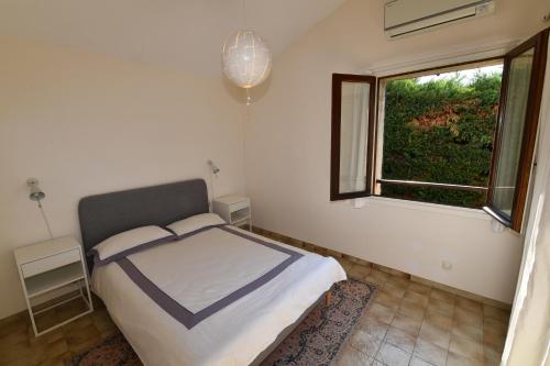 Schlafzimmer mit einem Bett und einem Fenster in der Unterkunft Haute Vue - Luxury Villa - Private Pool & Panoramic View in Montauroux