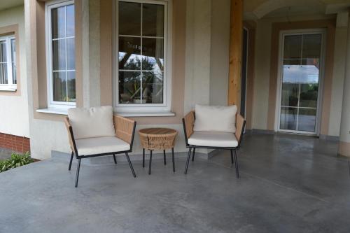 two chairs and a table sitting on a porch at Domek mamy in Tykocin
