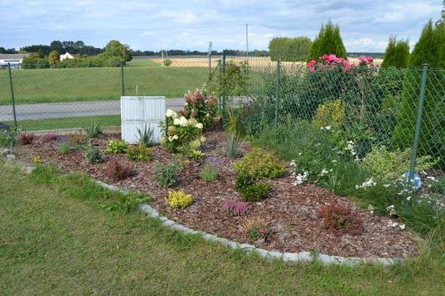 a garden with colorful flowers in a fence at Domek mamy in Tykocin