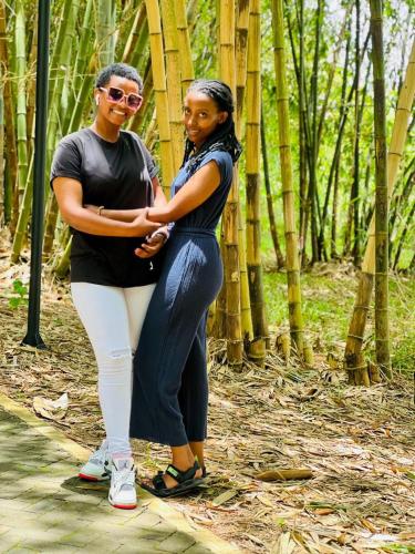 twee vrouwen die naast elkaar staan in een bos bij RUHENGELI,RWANDA 