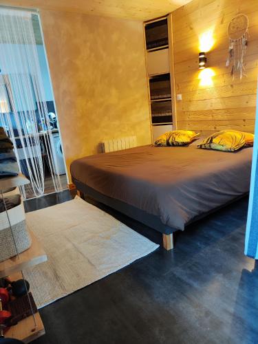 - une chambre avec un lit et un mur en bois dans l'établissement Superbe appartement neuf avec terrasse, à Orchamps-Vennes