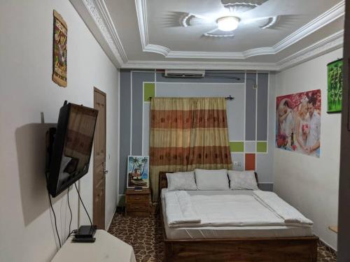 pokój z łóżkiem i telewizorem w obiekcie Hotel Bella Vida w mieście Lomé