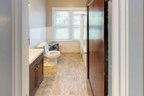 a bathroom with a toilet and a sink and a window at Large Group Downtown Rental - Westend in Nashville
