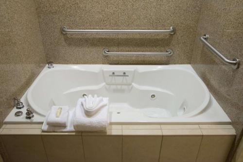 a white bath tub in a bathroom with towels at Hilton Garden Inn Laramie in Laramie