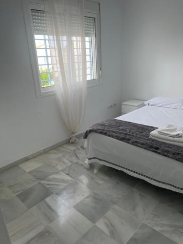ein Schlafzimmer mit einem Bett und Fliesenboden in der Unterkunft Casa con piscina privada in El Puerto de Santa María