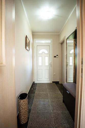 a hallway with a white door and a trash can at Zlatni Prag - Kraljevo in Kraljevo