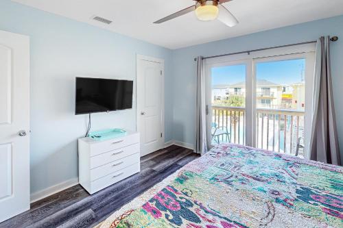 a bedroom with a bed and a flat screen tv at Sand Dollar #14 in Gulf Shores