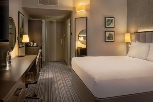 a hotel room with a large bed and a desk at DoubleTree by Hilton London Chelsea in London