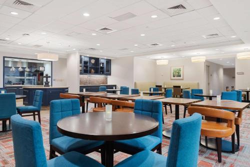 a dining room with tables and blue chairs at Hilton Garden Inn New Orleans French Quarter/CBD in New Orleans