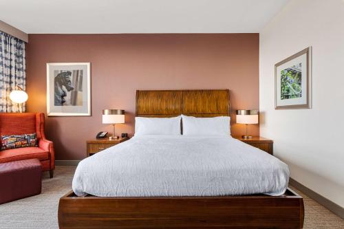 a bedroom with a large bed and a red chair at Hilton Garden Inn New Orleans French Quarter/CBD in New Orleans