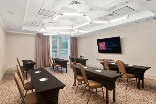 a conference room with tables and chairs and a screen at Hilton Garden Inn New Orleans French Quarter/CBD in New Orleans