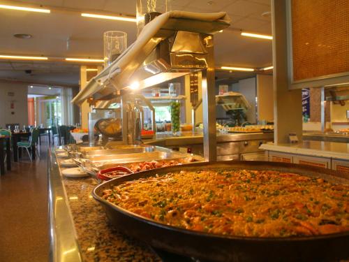 una línea de buffet con una gran pizza en un restaurante en AR Roca Esmeralda & SPA Hotel en Calpe