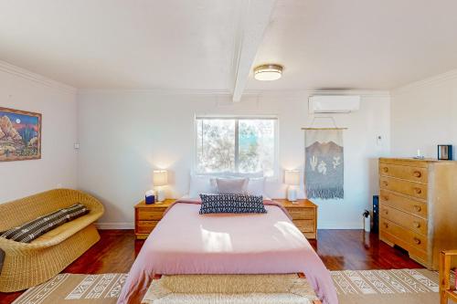 a bedroom with a large bed and a chair at Cacti Sanctuary in Sunfair Heights