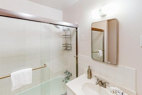 a white bathroom with a sink and a shower at Cacti Sanctuary in Sunfair Heights