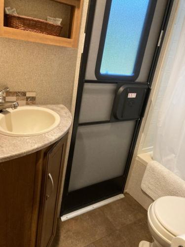uma casa de banho com um lavatório, um WC e uma janela. em Penn State Weekender em State College