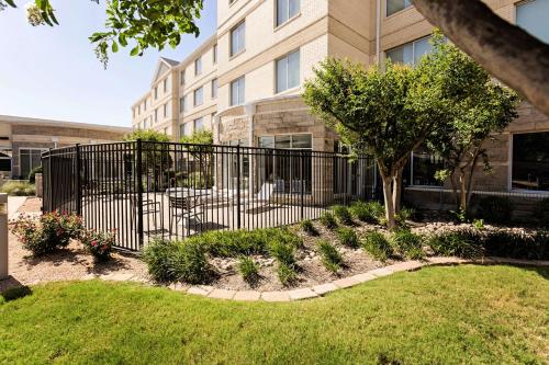 a fence in a yard in front of a building at Hilton Garden Inn Temple Medical Center in Temple